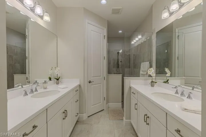 Full bathroom with two vanities and tiled shower