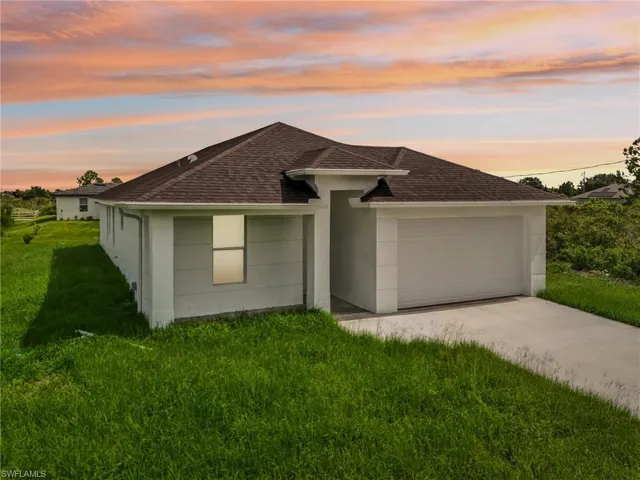 View of front facade with a garage and a lawn