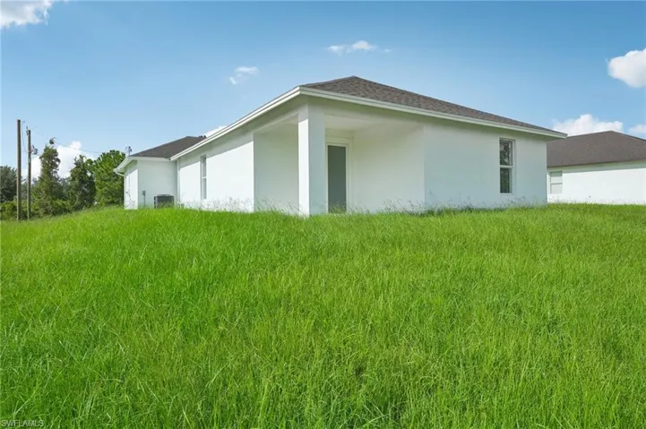 View of property exterior with a lawn