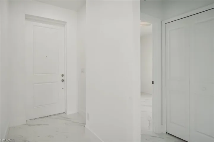 Corridor featuring light tile patterned flooring
