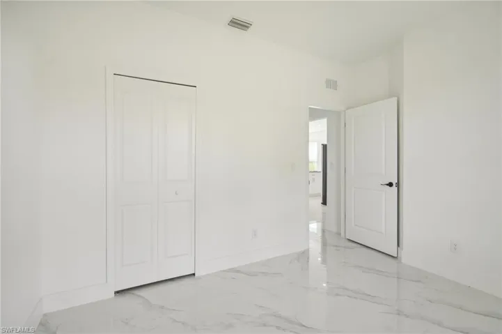 Unfurnished bedroom featuring light tile patterned flooring and a closet