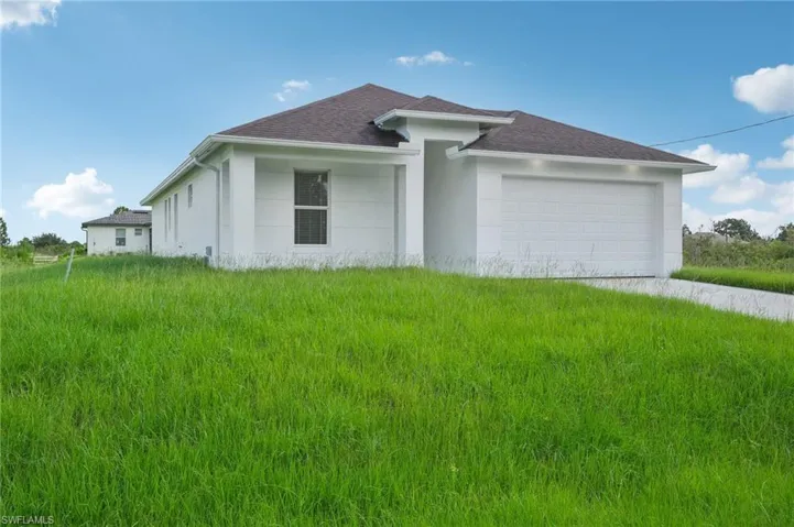 View of side of property with a garage and a yard