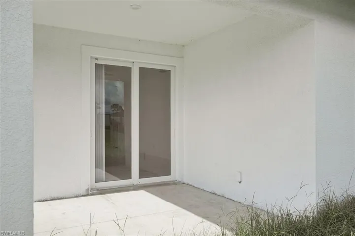 Doorway to property featuring a patio area
