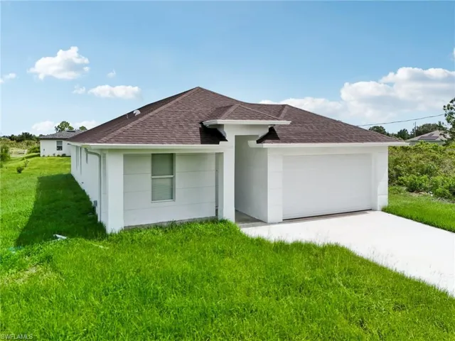 View of front of property with a garage and a front lawn