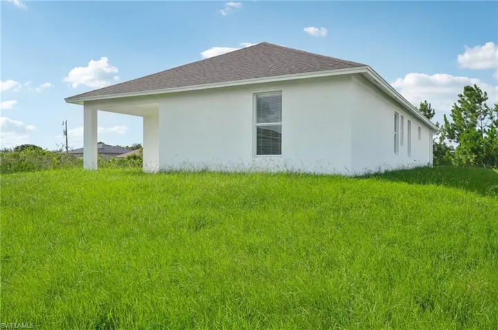 View of property exterior featuring a lawn