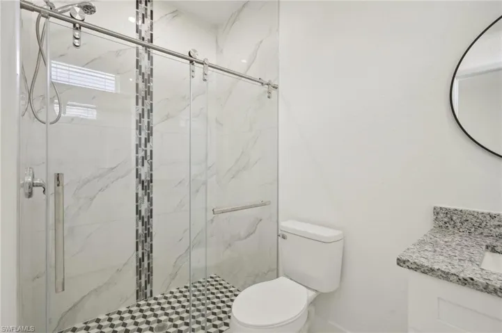 Bathroom with vanity, toilet, and an enclosed shower
