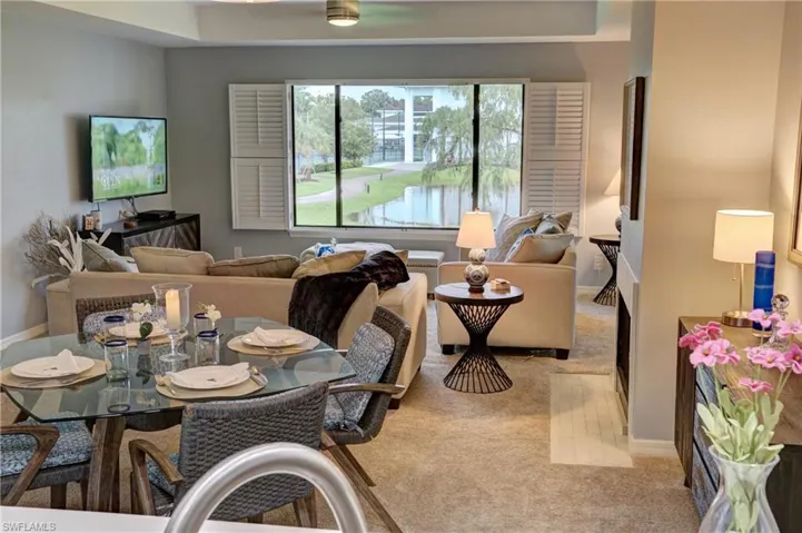 Carpeted living room with a tray ceiling