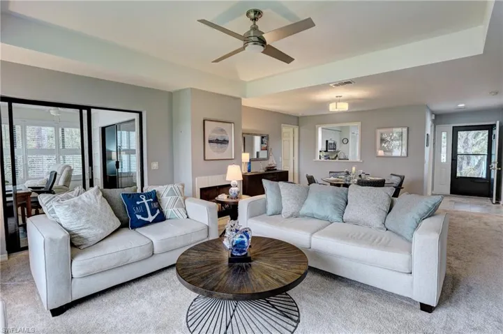 Living room featuring light colored carpet and ceiling fan