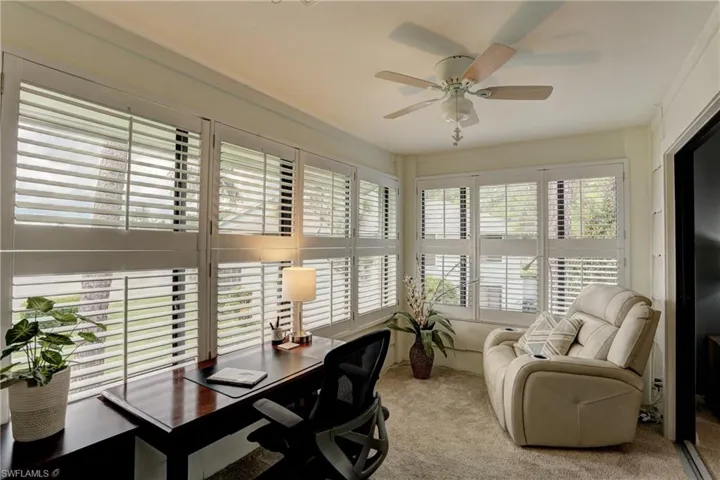 Carpeted office featuring ceiling fan