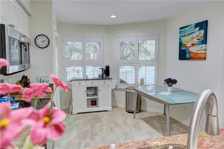 Kitchen featuring light tile patterned floors and white cabinets
