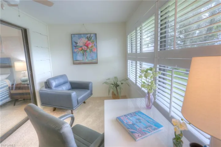 Carpeted living room featuring ceiling fan