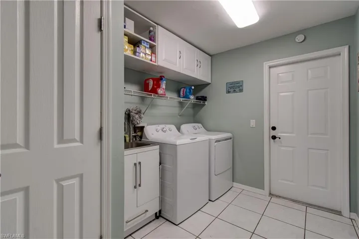 Laundry room featuring cabinet space, washing machine and clothes dryer, and light tile patterned floors