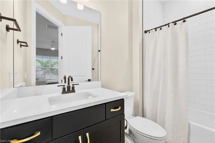 Full bath featuring vanity and shower / tub combo with curtain