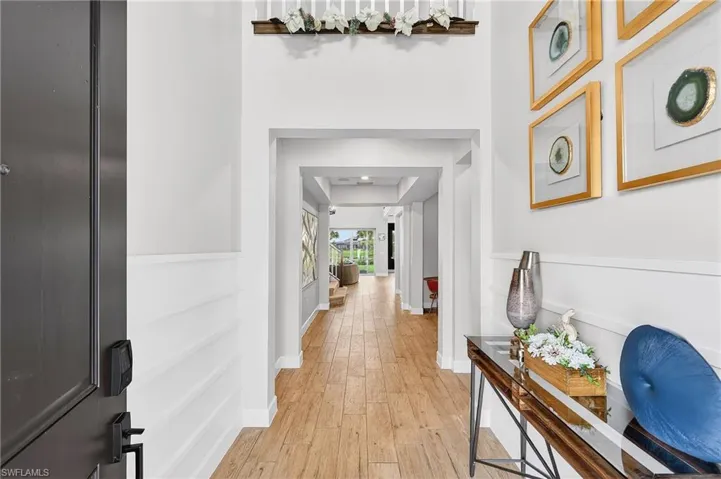 Hallway with light wood-style floors and a raised ceiling