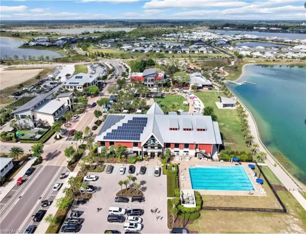 Drone / aerial view of a nearby body of water and a pool