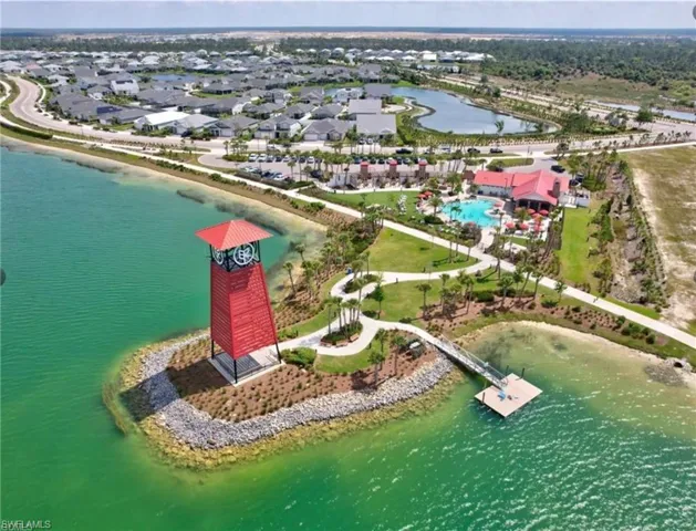 Aerial view of property and surrounding area featuring a nearby body of water and nearby suburban area