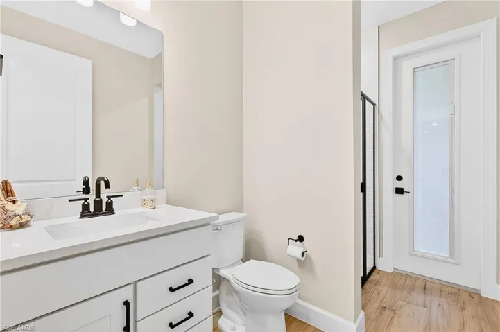 Bathroom featuring vanity, a stall shower, and light wood finished floors