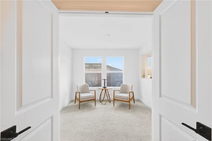 Sitting room with light carpet and baseboards