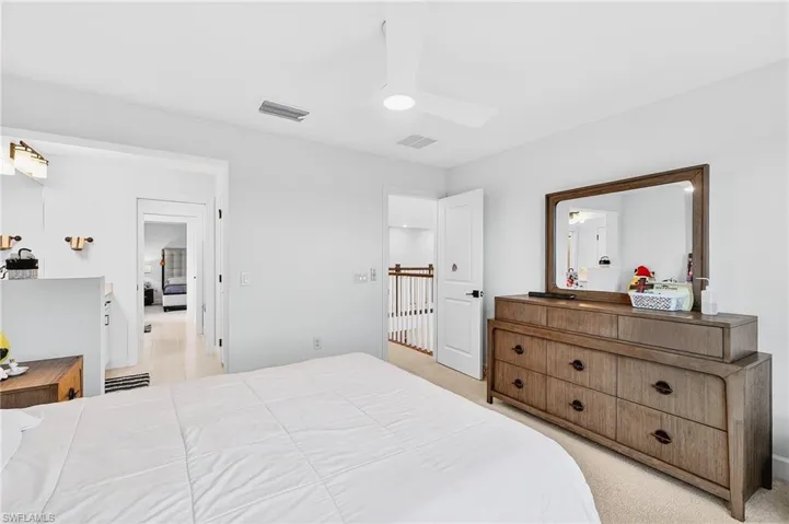 Bedroom with light colored carpet and a ceiling fan