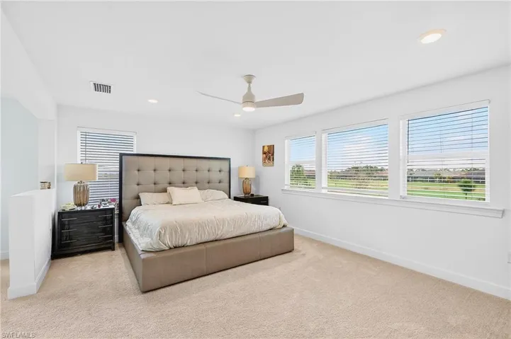 Carpeted bedroom with ceiling fan and recessed lighting