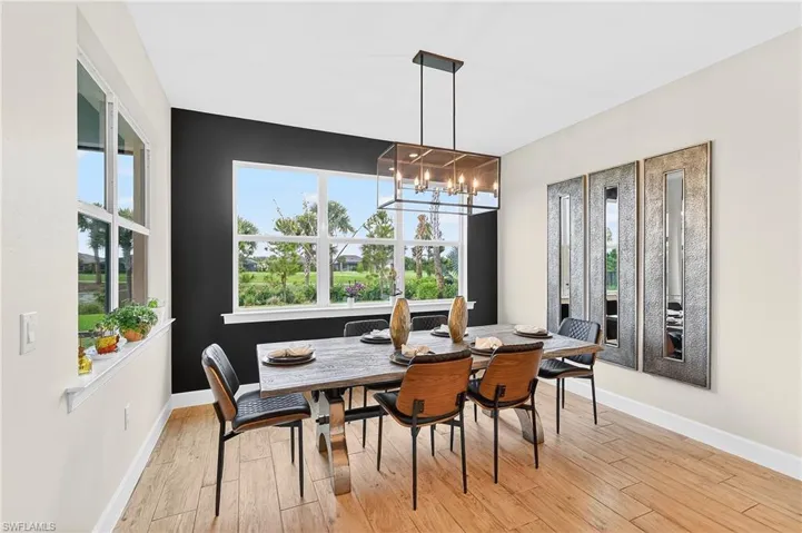 Dining room with light wood-style floors and hanging lights