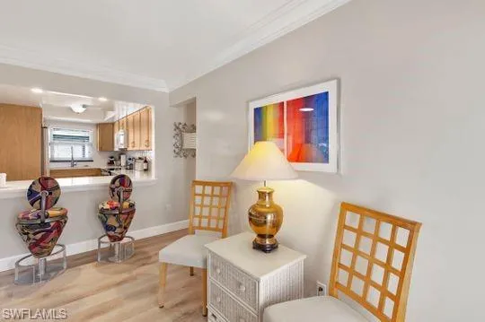 Living area featuring light wood-style floors and crown molding
