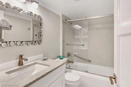 Bathroom with vanity and enclosed tub / shower combo