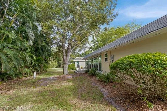 View of green lawn with a sunroom