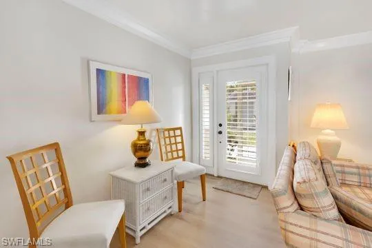 Sitting room with wood finished floors and crown molding