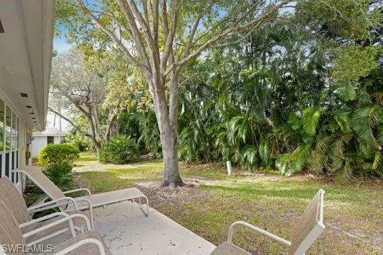 View of grassy yard with a patio area