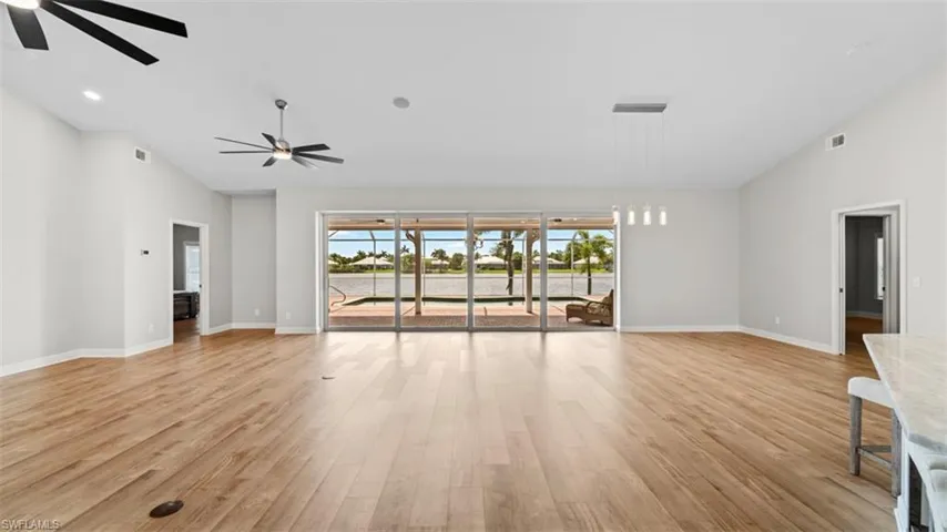 Unfurnished living room with ceiling fan and light hardwood / wood-style flooring