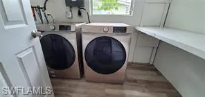 Laundry area with washer and dryer and light wood-style flooring