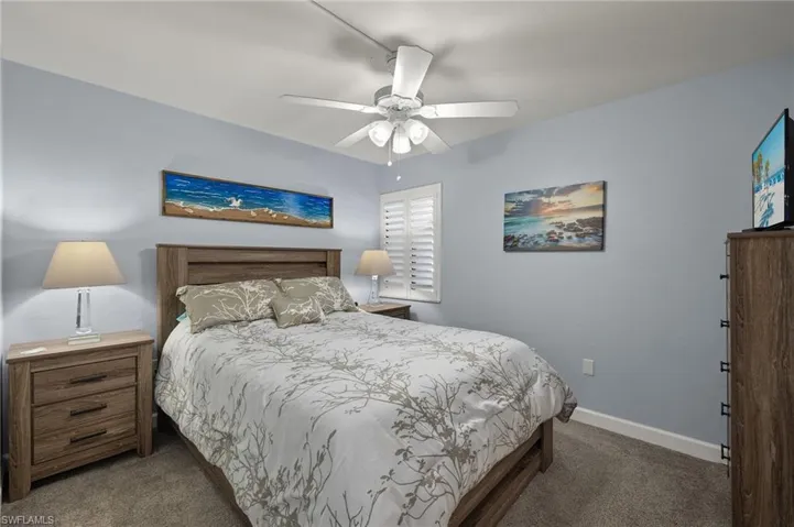 Carpeted bedroom featuring ceiling fan