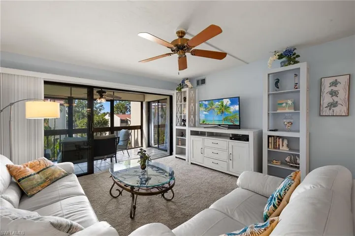 Carpeted living room featuring ceiling fan