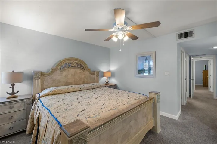 Carpeted bedroom featuring ceiling fan