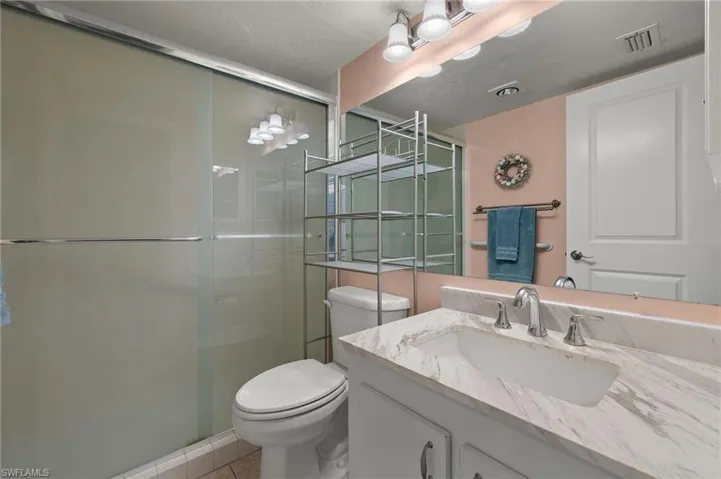 Bathroom featuring vanity, an enclosed shower, and toilet