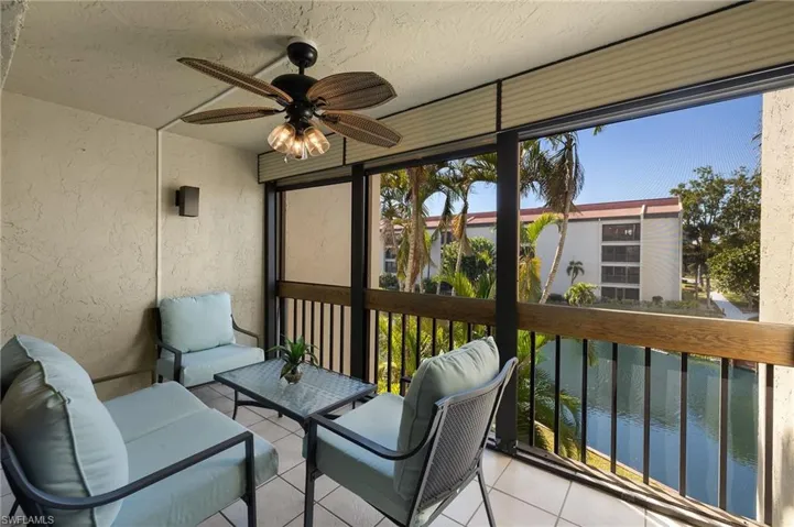 Sunroom / solarium with ceiling fan and a water view