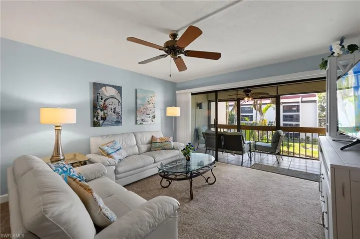 Carpeted living room with ceiling fan