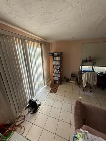 Tiled living room featuring a textured ceiling