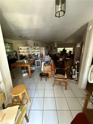 Tiled dining room with ceiling fan and lofted ceiling