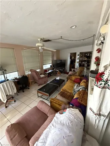 Living room featuring ceiling fan and light tile patterned flooring