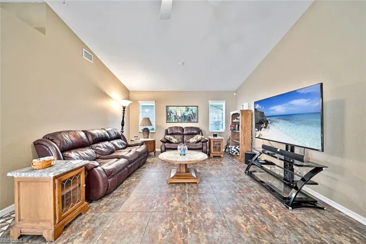 Living room with baseboards and lofted ceiling