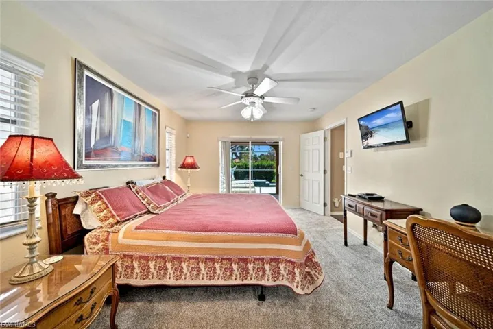 Carpeted bedroom featuring access to exterior and a ceiling fan