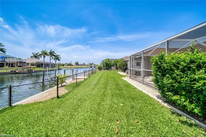 View of yard featuring a sunroom, a lanai, and a water view