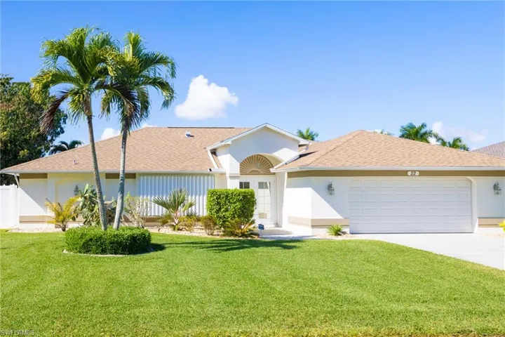 Ranch-style home with a front lawn, a shingled roof, concrete driveway, and an attached garage