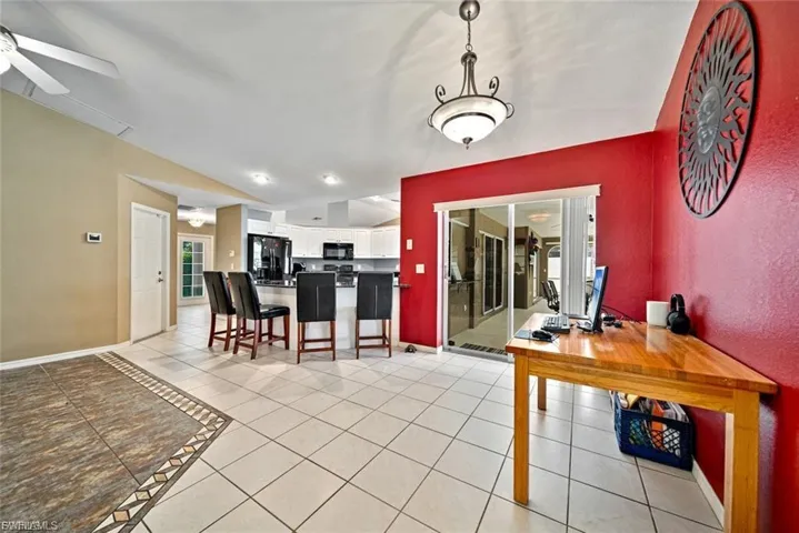 Dining area featuring lofted ceiling, light tile patterned flooring, and ceiling fan