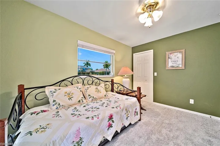 Bedroom with carpet, a textured wall, and ceiling fan