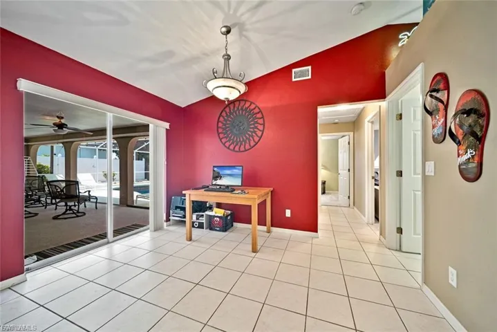 Dining space with lofted ceiling, ceiling fan, and light tile patterned floors