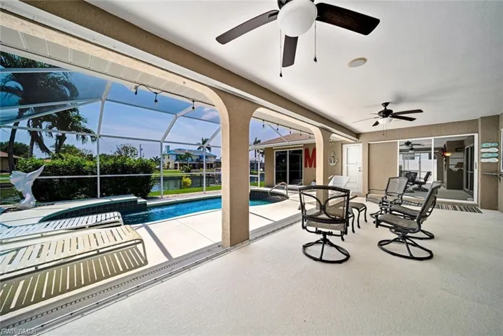Outdoor pool with a patio area, a sunroom, and glass enclosure