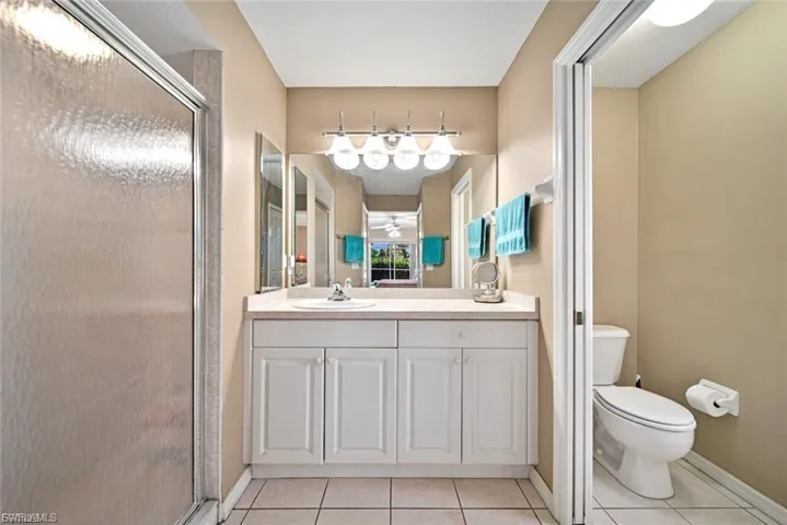 Full bath with a stall shower, light tile patterned floors, and vanity